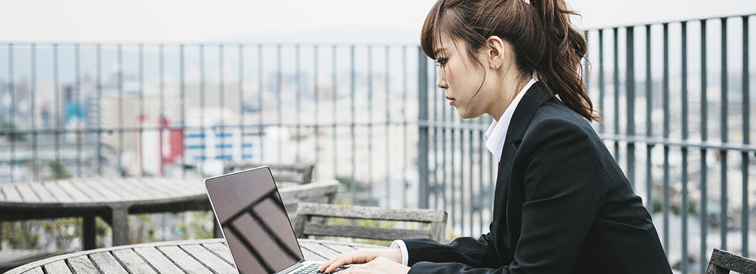 Une femme à Kyoto, au Japon, travaille à l'extérieur sur son ordinateur portable