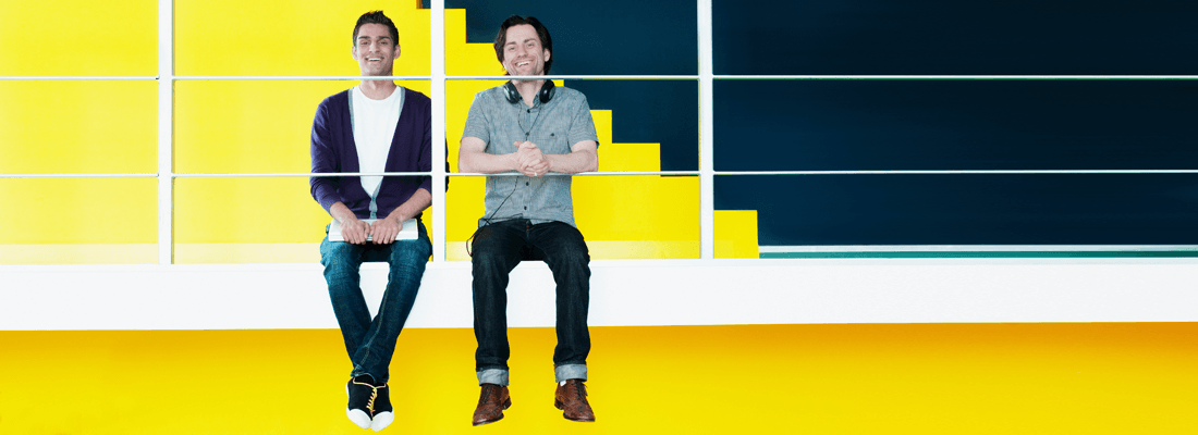 Dos hombres felices sobre un fondo amarillo en una oficina