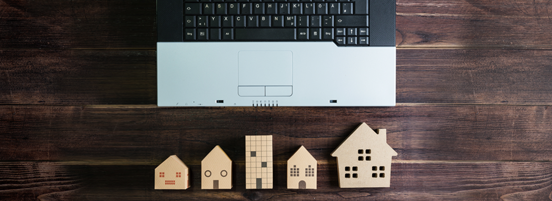 Модели деревянных домов рядом с ноутбуком