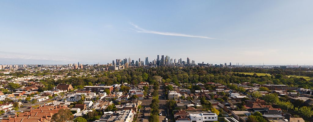 Aerial of Melbourne CBD skyline with suburban Melbourne residential area in the foreground.